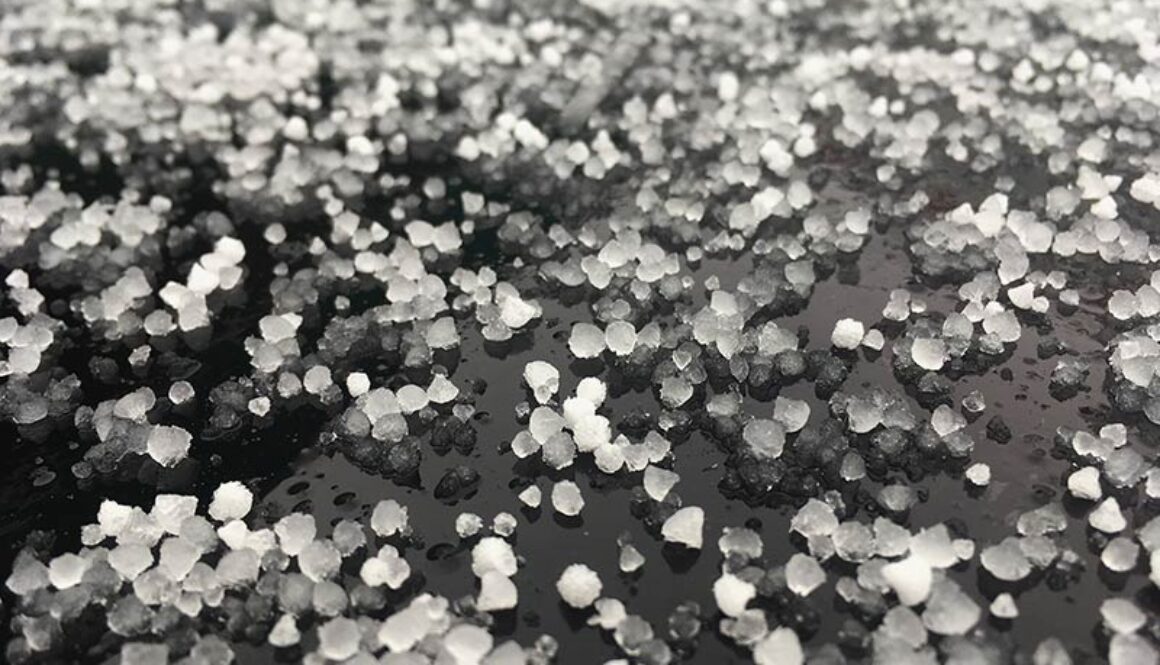 Large grains of hail on a black ground.