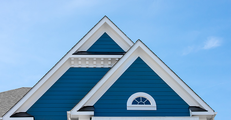 Blue siding near a home’s roof.