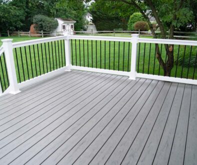 A gray deck with a white railing